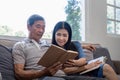 Happy elderly couple relax on couch in living room reading together for vacation holiday at home Royalty Free Stock Photo
