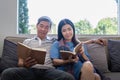 Happy elderly couple relax on couch in living room reading together for vacation holiday at home Royalty Free Stock Photo