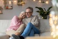 Happy elderly couple relaxing together on the sofa at home Royalty Free Stock Photo