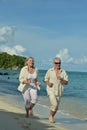 Happy elderly couple running at tropical beach Royalty Free Stock Photo