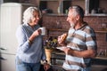 Happy elderly couple smiling at each other while drinking coffee Royalty Free Stock Photo