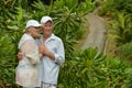 Happy elderly couple standing embracing in a tropical forest Royalty Free Stock Photo