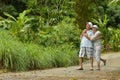 Happy elderly couple standing embracing in a tropical forest Royalty Free Stock Photo