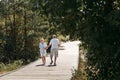 Happy elderly couple walking along a wooden path in the forest Royalty Free Stock Photo