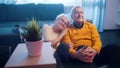 Happy elderly couple watching movies while sitting on the floor. Love and affection at old age Royalty Free Stock Photo