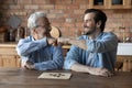 Happy elderly dad and grownup son giving fist bumps Royalty Free Stock Photo