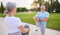 Healthy senior couple of husband and wife doing stretching exercises together in city park Royalty Free Stock Photo