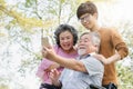 Happy elderly with family. Grandpa and grandma using mobile phone taking photo with grandson Royalty Free Stock Photo