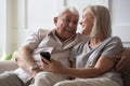 Elderly husband and middle-aged wife having fun using smartphone Royalty Free Stock Photo