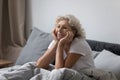 Happy elderly lady awaking in modern comfortable bedroom