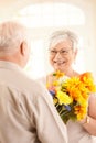 Happy elderly lady receiving flowers Royalty Free Stock Photo