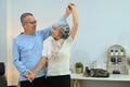 Happy elderly male and female pensioner having fun dancing in living room. Retirement lifestyle concept Royalty Free Stock Photo