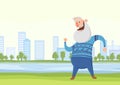 Happy elderly man dancing or doing morning sports exercises in city park. Active lifestyle and sport activities in old