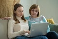 Happy elderly middle mother sitting on couch with her daughter, looking at laptop. Happy mature woman with her adult Royalty Free Stock Photo