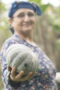 Happy elderly muslim woman farmer holding a single pumpkin