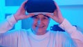 Happy elderly retired woman removing VR glasses and smiling.