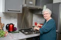 Happy elderly senior active woman cooking at home in a modern kitchen Royalty Free Stock Photo