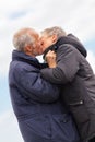 Happy elderly senior couple walking on beach