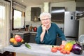 Happy elderly senior old active woman cooking at home in modern kitchen Royalty Free Stock Photo