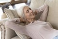 Happy elderly senior woman lying on couch with closed eyes Royalty Free Stock Photo