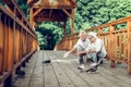Happy elderly white-haired couple feeding the pigeons on the bridge Royalty Free Stock Photo