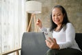 Happy elderly woman doing online shopping with smartphone using credit card Royalty Free Stock Photo