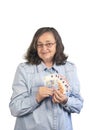 A happy elderly woman in glasses and a denim shirt smiles and holds in her hands bills of 20 and 10 euros. The concept of wealth Royalty Free Stock Photo
