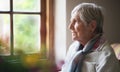 Happy elderly woman looking out window thinking of memories pensioner retirement lifestyle concept Royalty Free Stock Photo