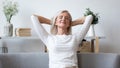 Happy elderly woman relax on sofa at home Royalty Free Stock Photo