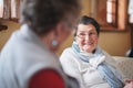 Happy elderly woman talking to friend sitting on sofa in retirement home having conversation Royalty Free Stock Photo