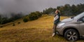 Happy elderly woman traveler standing near the car while traveling in the mountains. Active retirees travel and lifestyle Royalty Free Stock Photo