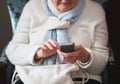Happy elderly woman using smartphone texting browsing on mobile phone sending messages sitting on couch at home Royalty Free Stock Photo