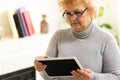 Happy Elderly woman using a tablet and laughing Royalty Free Stock Photo