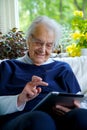 Happy Elderly woman using a tablet and laughing Royalty Free Stock Photo