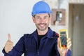 happy electrician measures voltage in construction site Royalty Free Stock Photo