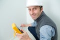 happy electrician measuring voltage socket in new building Royalty Free Stock Photo