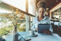 African American gril in bar with digital tablet and coffee