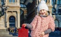 Happy elegant child showing red shopping bag in Milan, Italy