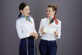 happy elegant female air hostesses against gray background Royalty Free Stock Photo