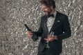 Happy elegant groom holding champagne bottle and glasses and smiling Royalty Free Stock Photo