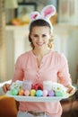 Happy elegant housewife holding easter decorated plate