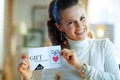 Happy elegant housewife showing gift certificate