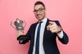 Happy elegant man holding trophy and pointing finger Royalty Free Stock Photo