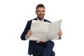 Happy elegant man in suit smiling and reading newspaper Royalty Free Stock Photo