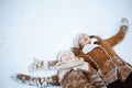 Happy elegant mother and child making snow angel Royalty Free Stock Photo