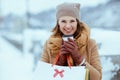 happy elegant woman in brown hat and scarf in camel coat