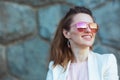 happy elegant woman in pink dress and white jacket in city