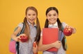 Happy elementary school children hold tasty apples fruit yellow background, food knowledge