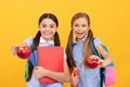 Happy elementary school children hold tasty apples fruit yellow background, food knowledge