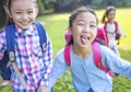 Happy elementary school kids running on the grass Royalty Free Stock Photo